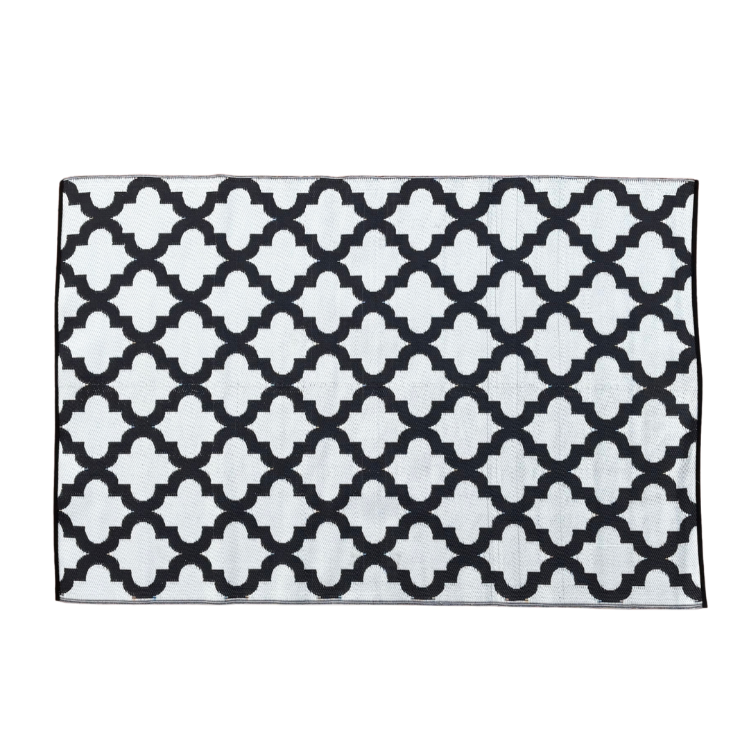 The Large Casablanca Outdoor Reversible Mat by Florastyle By Hingham is a lightweight, double-woven rug with a white background and black geometric trellis pattern for a modern, stylish look. Water resistant and perfect for outdoor use.