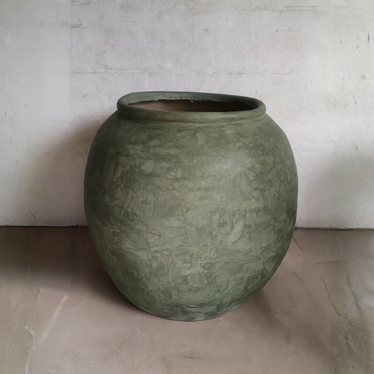Green ceramic pot on a neutral background