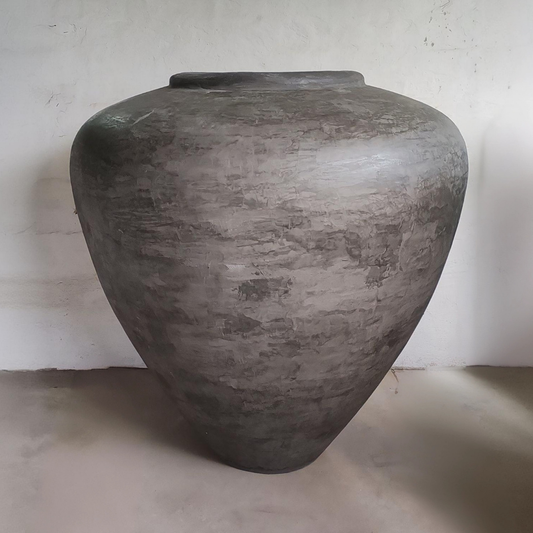 Large gray stone colour fibreglass vase on a plain surface with a light gray background