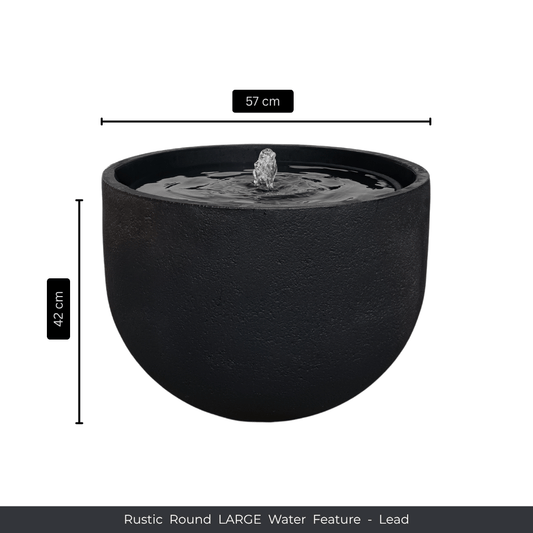 A large, round, rustic lead-colored water feature by Florastyle By Hingham with a central fountain. Measuring 57 cm diameter x 42 cm high. Text at the bottom: Water Feature - Rustic Round. Made from polyresin, durable and waterproof, yet lightweight. Suitable for indoor and outdoor spaces.
Colour: Lead
Price: R3625