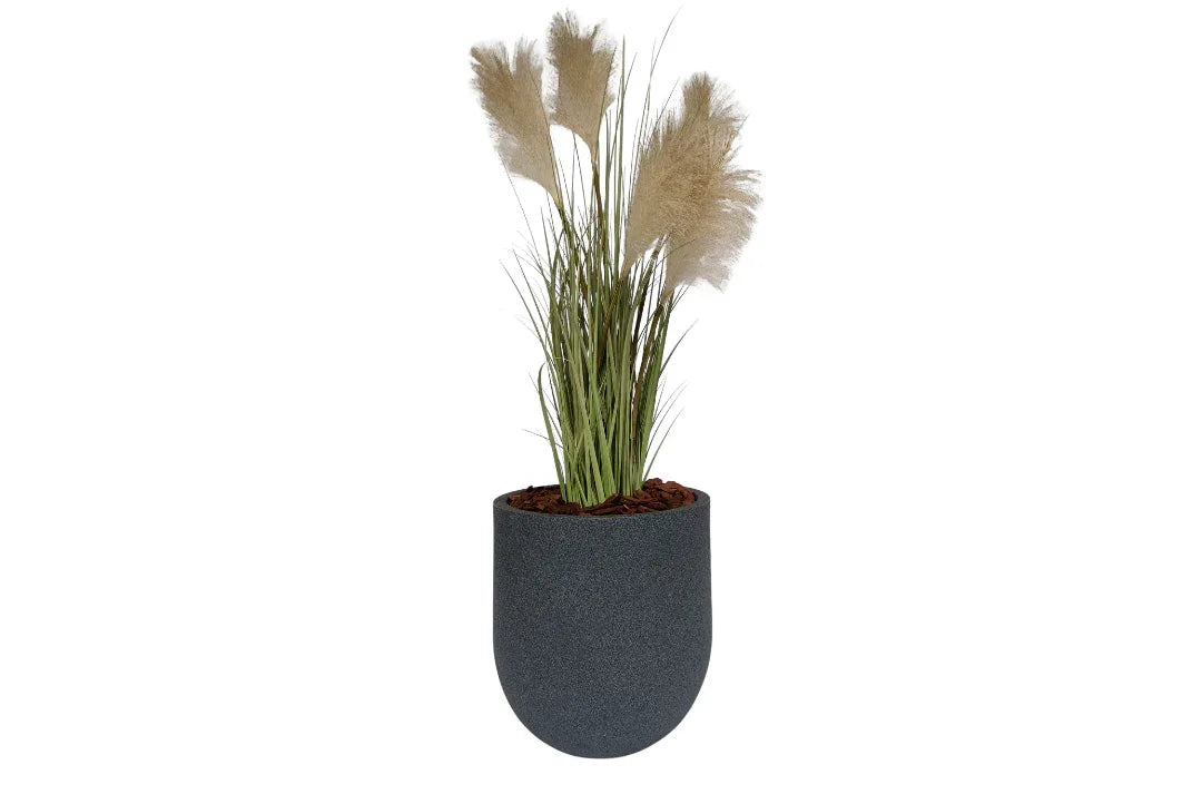 A tall artificial pampas grass plant with feathery beige plumes and green leaves in a modern, dark gray rounded pot.