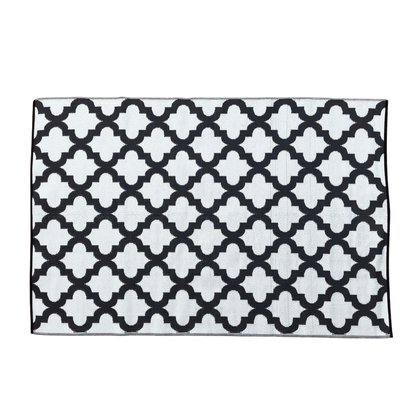 The Large Casablanca Outdoor Reversible Mat by Florastyle By Hingham is a lightweight, double-woven rug with a white background and black geometric trellis pattern for a modern, stylish look. Water resistant and perfect for outdoor use.