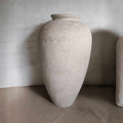 Large textured stone vase against a neutral background
