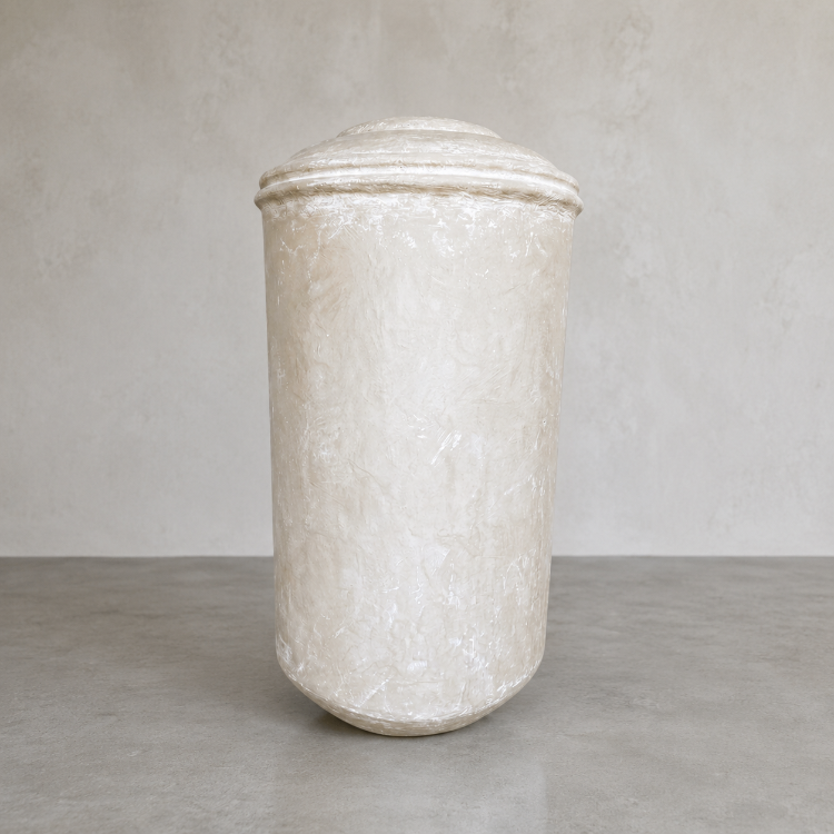 The Damascus Organic Fiberglass Pot - Earth Range by Florastyle By Hingham is a large, off-white cylindrical planter with a domed lid, placed on a gray surface against a light textured wall—perfect for modern interiors.