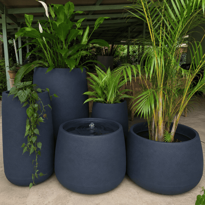 The Full Bios Set by Florastyle By Hingham includes five large UV-resistant polyresin planters with lush ferns and palms, and one features a Bios Medium water feature. The arrangement sits outdoors under a shelter.