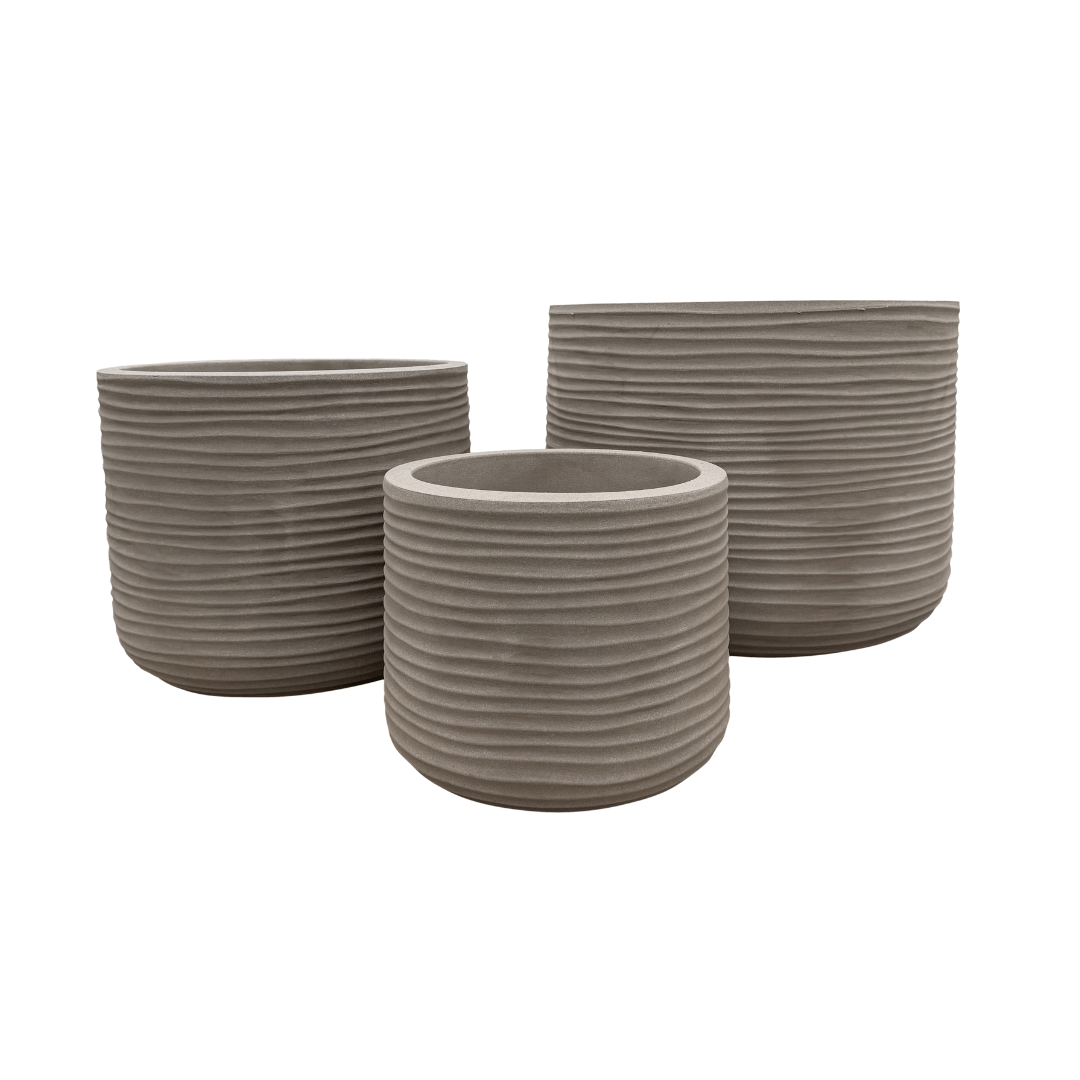 Three round, gray, ribbed Lagoon Round Japi Planters by Florastyle By Hingham in varying sizes are grouped together against a white background, showcasing a sleek and modern planter aesthetic.