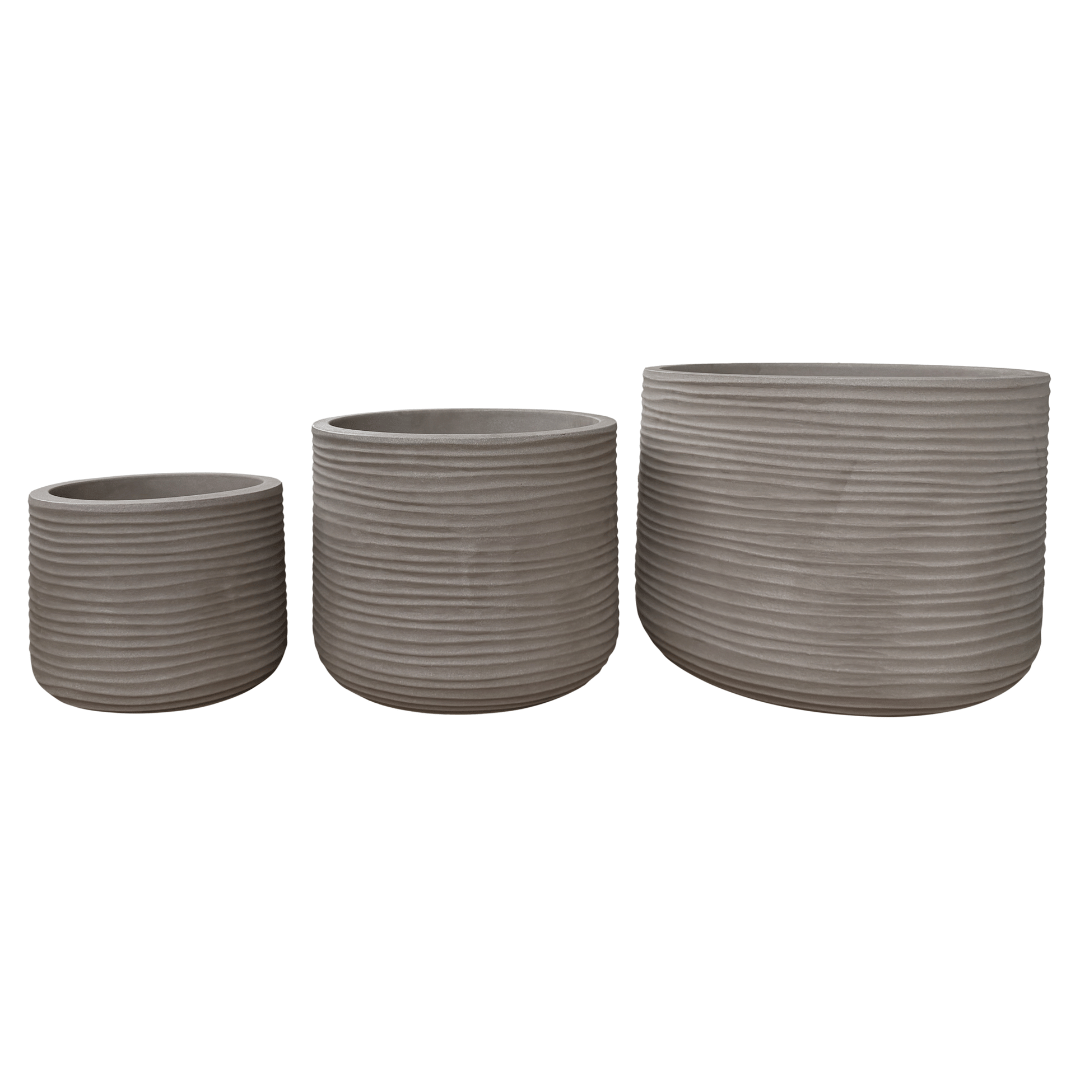 Three gray, ribbed, cylindrical Lagoon Round Japi Planters by Florastyle By Hingham in assorted sizes are arranged from smallest to largest against a white background, providing a modern planter aesthetic that complements any space.