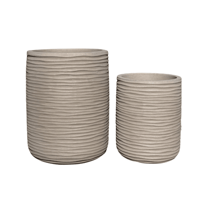 Two beige Lagoon Tall Japi Planters by Florastyle By Hingham, each of different heights, feature a matte, stone-like finish and a textured horizontal ribbed design. Crafted from lightweight polyresin, these modern planters offer style and practicality.