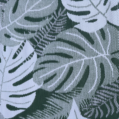 Close-up of the Florastyle By Hingham Medium Lima Outdoor Reversible Mat, showcasing its lightweight, double woven texture and large green and white tropical leaf pattern. Water-resistant for versatile outdoor use.