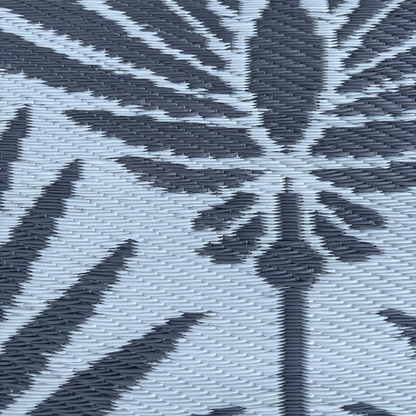 Close-up of the Florastyle By Hingham Medium Mumbai Outdoor Reversible Mat, showcasing its lightweight, double woven plastic design with a black and gray abstract leaf pattern on a light gray background. Water resistant.