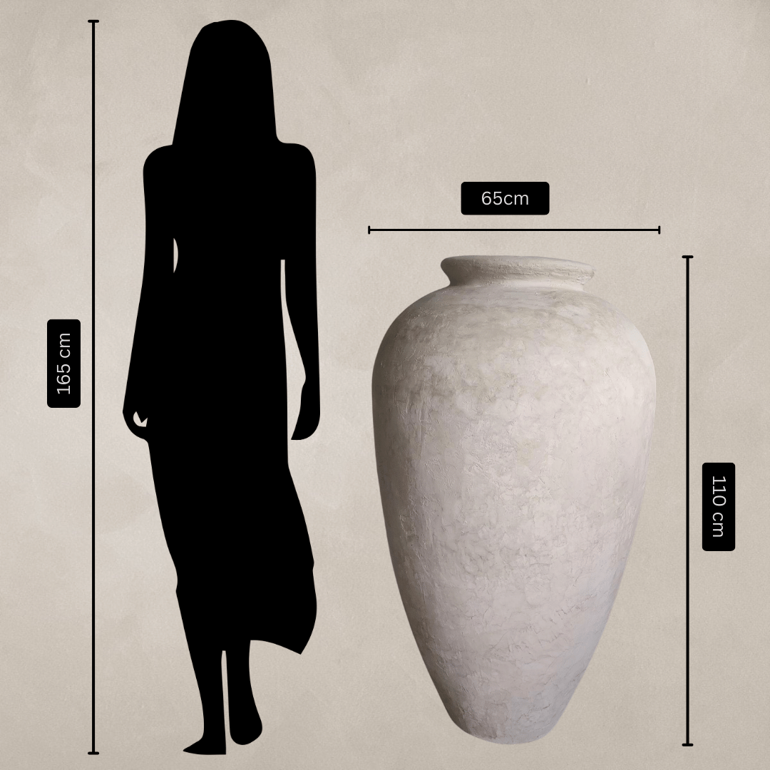 A 165cm-tall woman stands next to the Florastyle By Hingham Rhodes Organic Fiberglass Pot - Earth Range, which is white, lightweight, 110cm tall and 65cm wide; both shown against a plain background with measurement labels.
