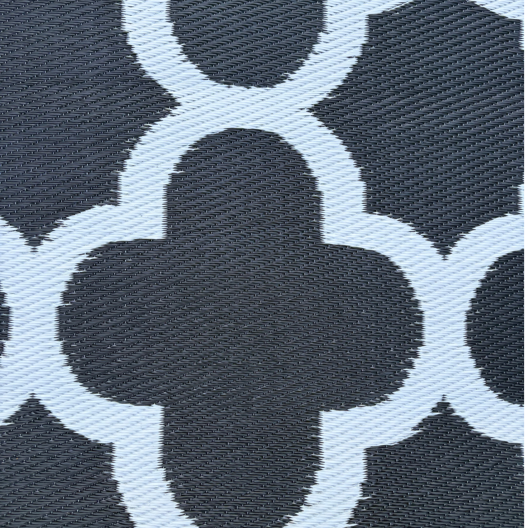Close-up of the Florastyle By Hingham Medium Tripoli Outdoor Reversible Mat, featuring lightweight, double-woven textured fabric and a black-and-white geometric quatrefoil pattern with water resistance.