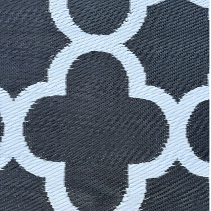 Close-up of the Florastyle By Hingham Medium Tripoli Outdoor Reversible Mat, featuring lightweight, double-woven textured fabric and a black-and-white geometric quatrefoil pattern with water resistance.