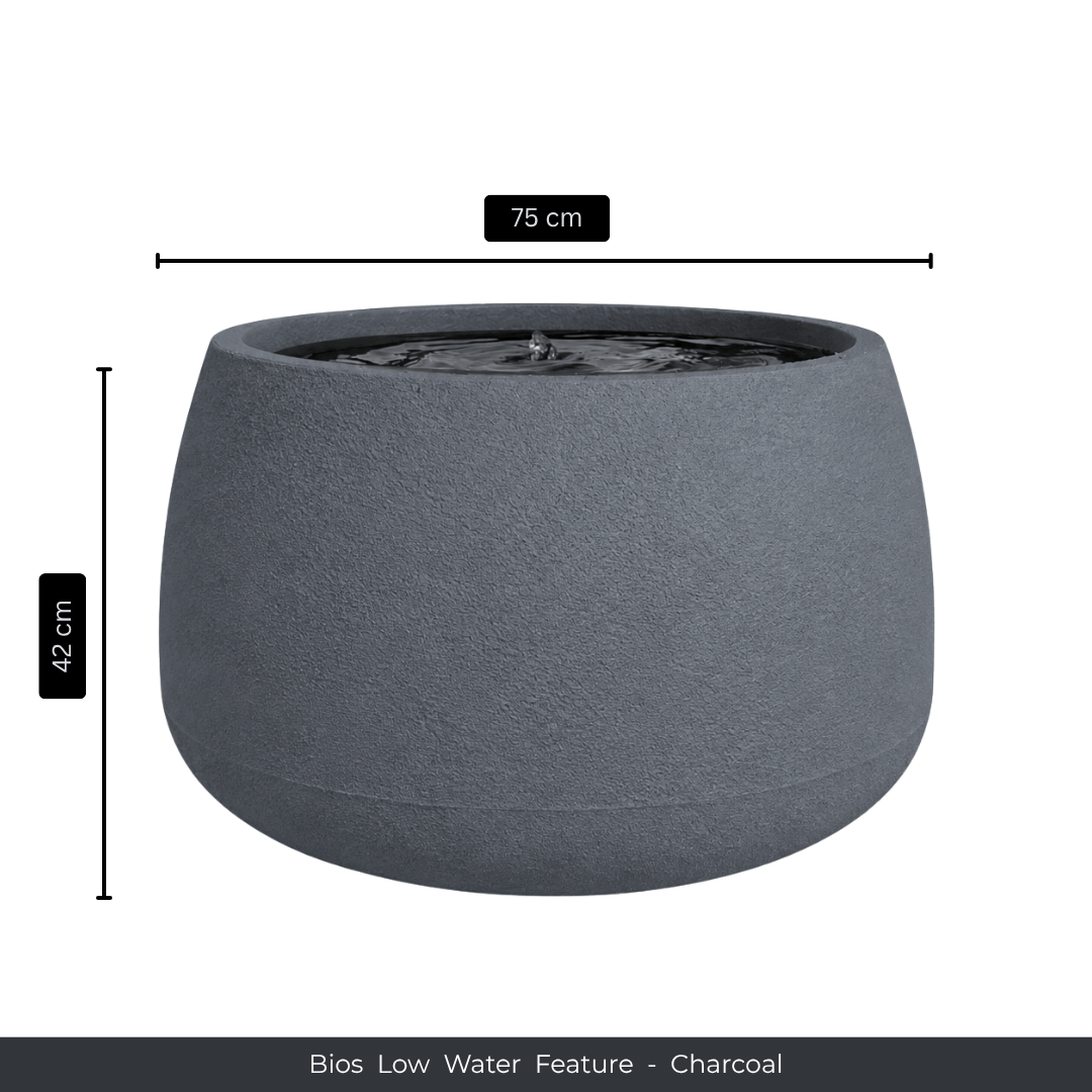 A charcoal, round indoor fountain by Florastyle By Hingham, 75 cm wide and 42 cm tall. Water flows on top, adding a calming modern touch. Text below: "Water Feature - Bios Low - Charcoal. Made from polyresin, durable and waterproof, yet lightweight. Suitable for indoor and outdoor spaces.
Colour: Charcoal
Price: R5195