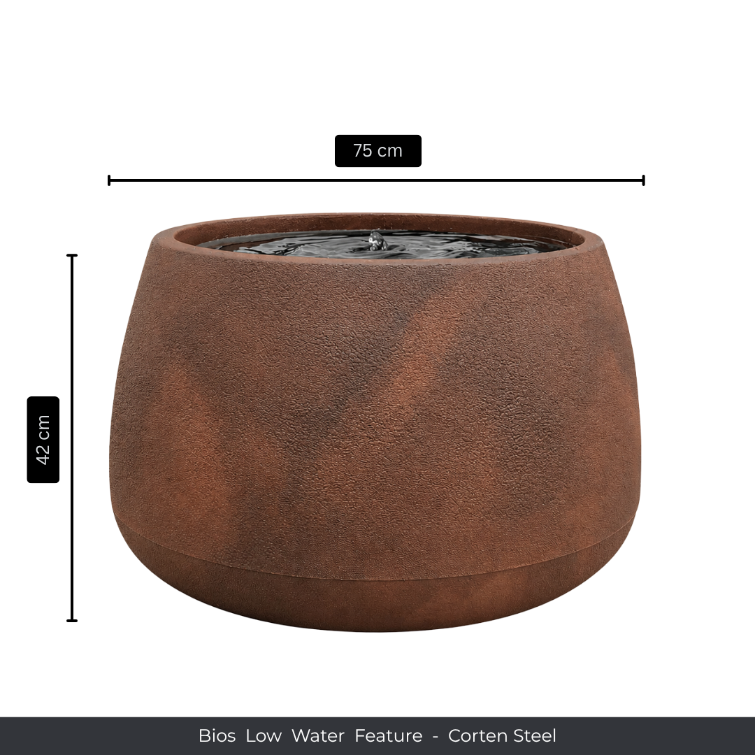 A round, rust-colored corten steel fountain by Florastyle By Hingham, with bubbling water at the top. Measures 75 cm wide and 42 cm tall. Product: Water Feature - Bios Low. Perfect as an indoor water feature.