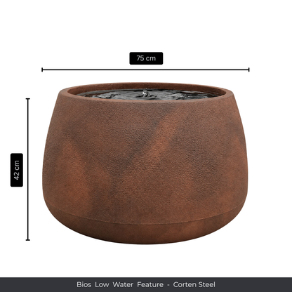 A round, rust-colored corten steel fountain by Florastyle By Hingham, with bubbling water at the top. Measures 75 cm wide and 42 cm tall. Product: Water Feature - Bios Low. Perfect as an indoor water feature.