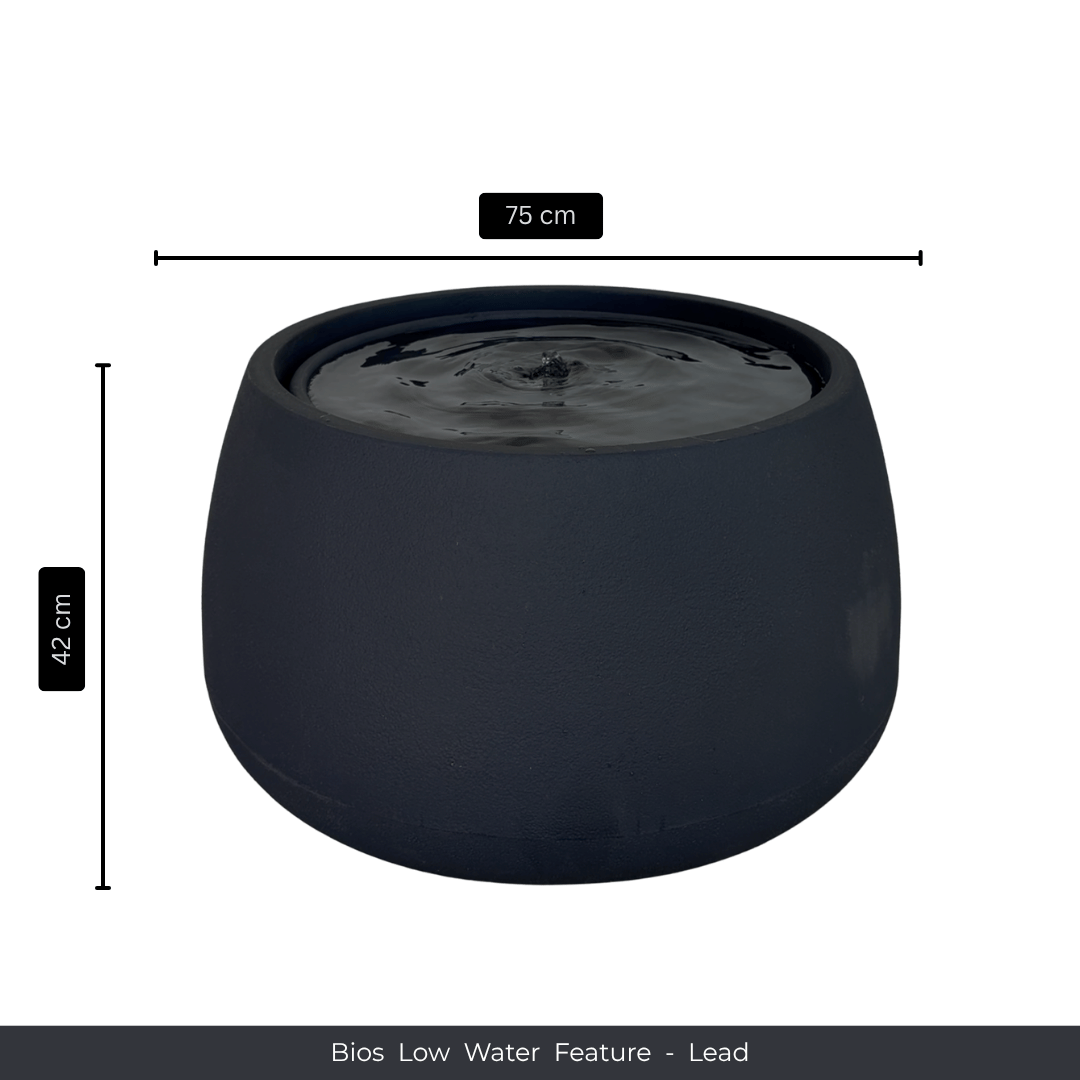 A round, dark grey indoor fountain by Florastyle By Hingham, 75 cm wide and 42 cm tall, features still water on top. The caption reads: Water Feature - Bios Low. Measurement arrows appear beside and above the fountain. Made from polyresin, durable and waterproof, yet lightweight. Suitable for indoor and outdoor spaces.
Colour: Lead
Price: R5195