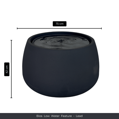 A round, dark grey indoor fountain by Florastyle By Hingham, 75 cm wide and 42 cm tall, features still water on top. The caption reads: Water Feature - Bios Low. Measurement arrows appear beside and above the fountain. Made from polyresin, durable and waterproof, yet lightweight. Suitable for indoor and outdoor spaces.
Colour: Lead
Price: R5195