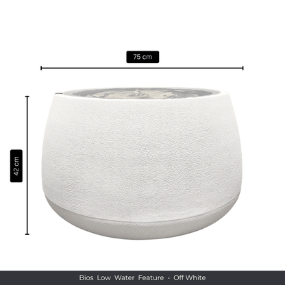A round, off-white textured indoor fountain with a wide bowl (75 cm diameter, 42 cm height), filled with water. Text below reads: Water Feature - Bios Low by Florastyle By Hingham. Made from polyresin, durable and waterproof, yet lightweight. Suitable for indoor and outdoor spaces.
Colour: Off White
Price: R5195