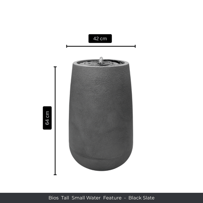 The Water Feature - Bios Tall Small by Florastyle By Hingham is a tall, cylindrical black slate fountain with water bubbling at the top, suitable for indoors or outdoors. Measures 64 cm high and 42 cm wide. Shown on a plain white background with labeled dimensions. Made from polyresin, durable and waterproof, yet lightweight. Suitable for indoor and outdoor spaces.
Colour: Black Slate
Price: R4045