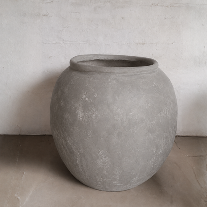 The Delphi Organic Fiberglass Pot - Earth Range by Florastyle By Hingham features a wide opening and wabi-sabi style, adding grace to any room with its smooth, round design. Perfect for displaying on floors against textured walls.