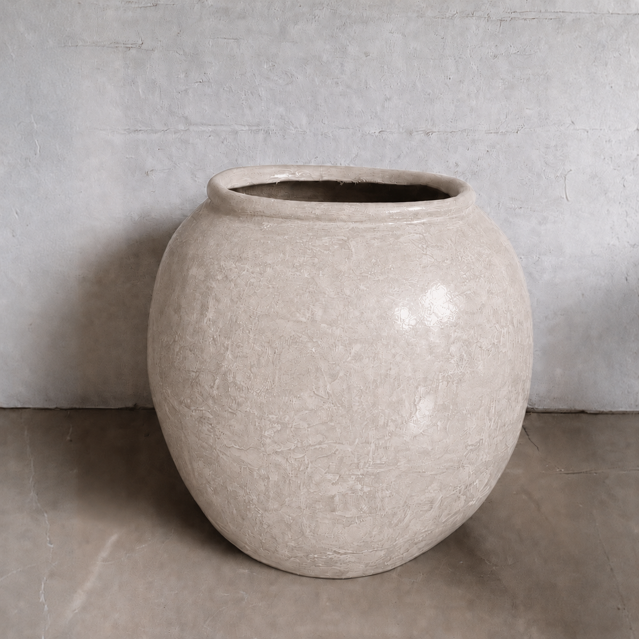 The Delphi Organic Fiberglass Pot - Earth Range by Florastyle By Hingham features a textured beige finish and round shape, creating an elegant accent on any floor or against light gray walls—perfect for stylish, modern spaces.