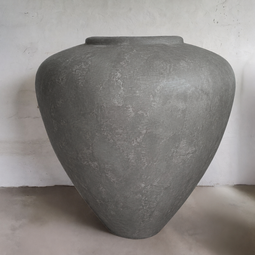 The Mykonos Organic Fiberglass Pot - Earth Range by Florastyle By Hingham features a large, smooth grey design with a wide body and narrow opening—ideal as sculptural décor for plain, light walls and floors.