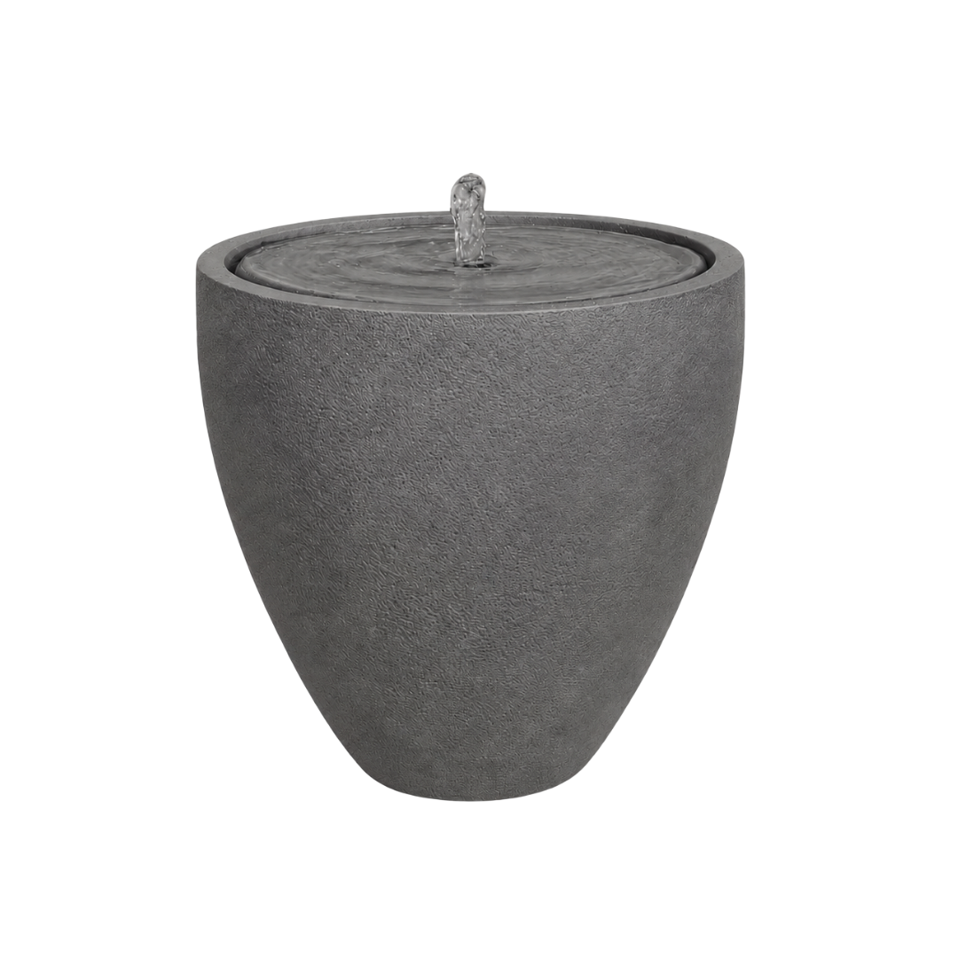 The Water Feature - Rustic Ellipse Small by Florastyle By Hingham is a modern, round gray stone outdoor fountain with a textured surface and central bubbling stream—perfect for adding rustic charm to any space.