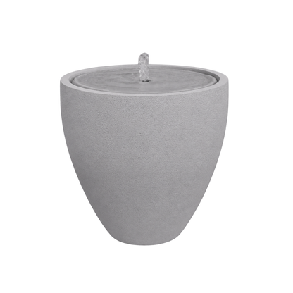 The Water Feature - Rustic Ellipse Small by Florastyle By Hingham is a modern, round, light gray stone fountain with a smooth surface and bubbling central spout, perfect as a calming indoor or outdoor accent.