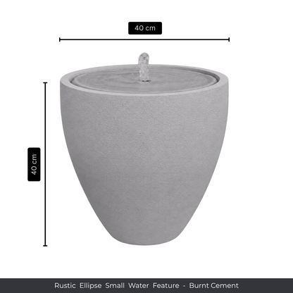 The Water Feature - Rustic Ellipse Small by Florastyle By Hingham is a grey, burnt cement, ellipse-shaped piece (40 cm high/wide) with a central spout—ideal for adding rustic charm to any indoor or outdoor space.