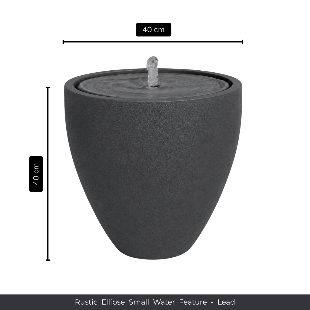 A round, dark gray rustic ellipse water feature with a gentle fountain, ideal for indoor or outdoor use. 40 cm wide x 40 cm tall. Florastyle By Hingham Water Feature - Rustic Ellipse Small.