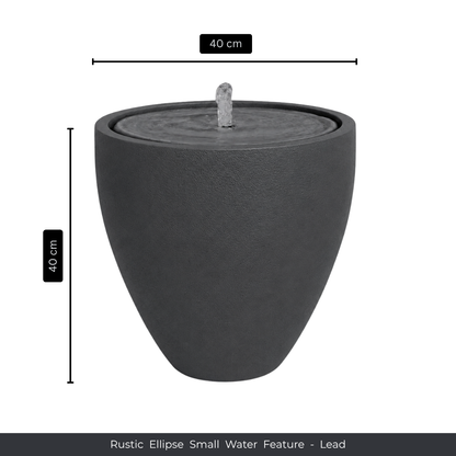 A round, dark gray rustic ellipse water feature with a gentle fountain, ideal for indoor or outdoor use. 40 cm wide x 40 cm tall. Florastyle By Hingham Water Feature - Rustic Ellipse Small.