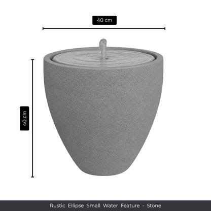 The Florastyle By Hingham Water Feature - Rustic Ellipse Small is a round, gray stone piece (40 cm high/wide) with a gentle top spout. Its smooth surface and subtle ripple effect make it ideal for indoor or outdoor spaces.