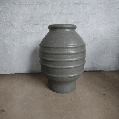The Sparta Organic Fiberglass Pot - Earth Range by Florastyle By Hingham features a gray, textured finish, rounded body, three ridges, and a narrow opening—ideal as a modern indoor planter for any space.