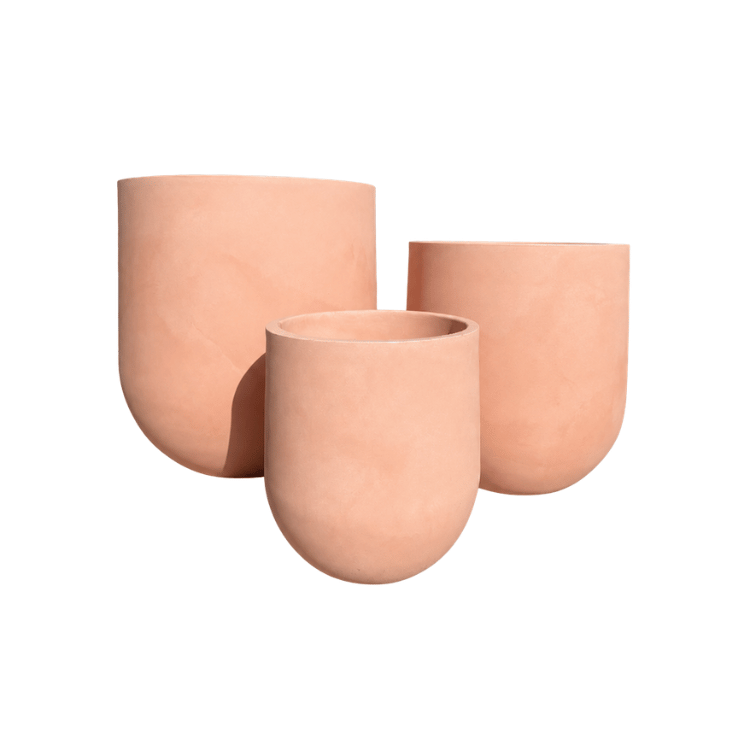 Three peach-colored Traditional Cask Japi Planters by Florastyle By Hingham, featuring minimalist rounded designs in varying heights and sizes, are grouped together against a white background.