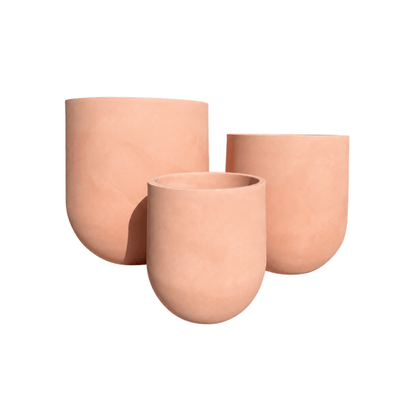 Three peach-colored Traditional Cask Japi Planters by Florastyle By Hingham, featuring minimalist rounded designs in varying heights and sizes, are grouped together against a white background.