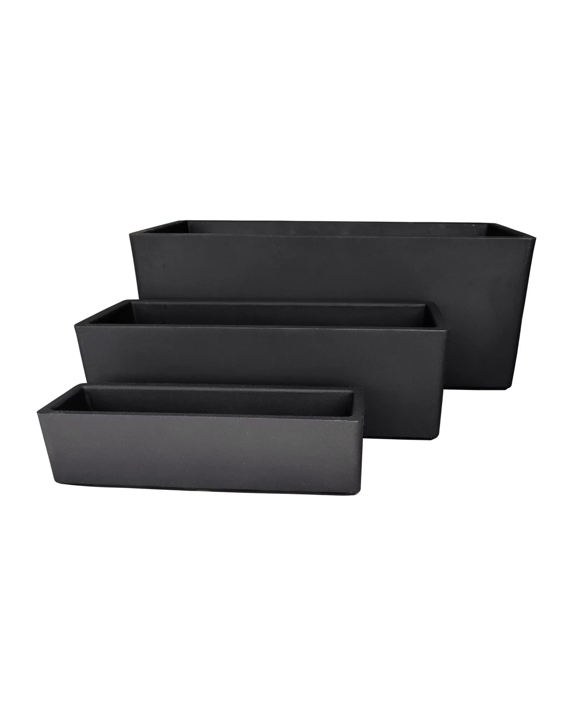 Three black Flat Japi Window Box - Double Walled planters by Florastyle By Hingham, in varying sizes, are stacked in a staggered arrangement with the smallest in front and largest at the back, against a plain white background.